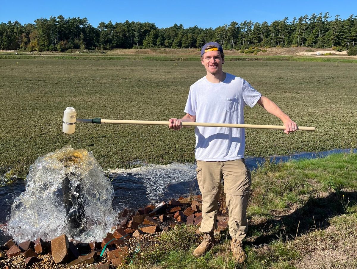 Adrian collecting a grab sample on an active cranberry farm while working for USDA-ARS 